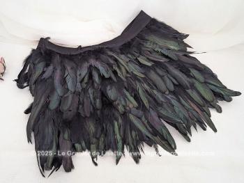 Taille 42,  voici une belle jupe courte, élégante et théâtrale à la fois, toute en plumes noires aux reflets irisés, portant l'étiquette de la marque  française reconnue pour ses créations audacieuses 