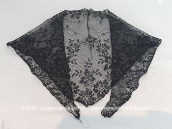 De forme triangulaire, voici une mantille vintage en fine dentelle noire toute en dentelle mécanique avec une belle guirlande de fleurs sur les contours et un grand dessin de bouquet de fleurs sur la partie en pointe. 