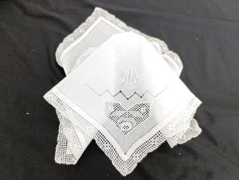 Voici un ancien mouchoir mariée fait main en batiste bordé d'une fine dentelle et décoré à partir de jeux de jours, d’incrustations et des monogramme ML brodés. Pièce unique.