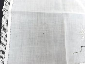 Voici un ancien mouchoir mariée fait main en batiste bordé d'une fine dentelle et décoré à partir de jeux de jours, d’incrustations et des monogramme ML brodés. Pièce unique.
