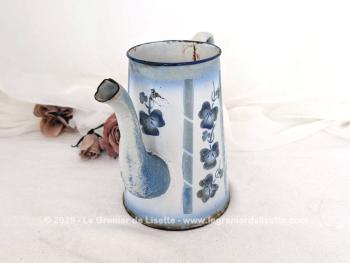Voici une ancienne cafetière émaillée, sans couvercle mais signée, habillé d'un décor vertical de guirlande et de fleurs, prete à être exposée pour une décoration au charme authentique avec ses éclats.