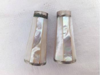 Charmant ancien duo salière et poivrière en nacre à facettes, aux reflets nacrés et au charme ancien, avec de très légères traces d’oxydation qui leur donnent tout leur caractère. Pour une table originale.