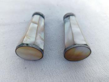 Charmant ancien duo salière et poivrière en nacre à facettes, aux reflets nacrés et au charme ancien, avec de très légères traces d’oxydation qui leur donnent tout leur caractère. Pour une table originale.