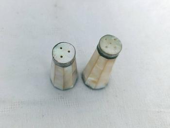Charmant ancien duo salière et poivrière en nacre à facettes, aux reflets nacrés et au charme ancien, avec de très légères traces d’oxydation qui leur donnent tout leur caractère. Pour une table originale.