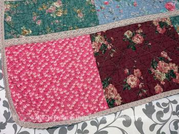 Voici un  plaid bien original de 155 x 155 réalisé en boutis de patchwork de différents tissus multicolores aux tons pastel, tous reliés entre eux par de la dentelle aux fuseaux. Travail artisanal de 