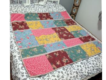 Voici un  plaid bien original de 155 x 155 réalisé en boutis de patchwork de différents tissus multicolores aux tons pastel, tous reliés entre eux par de la dentelle aux fuseaux. Travail artisanal de 