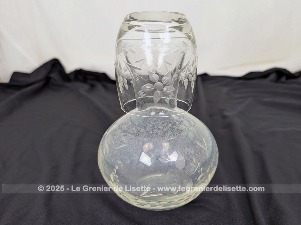 Voici un bel ensemble de nuit vintage comprenant une carafe à eau et son verre assorti faisant office de bouchon, en verre transparent finement ciselé de motifs floraux. Parfait pour une décoration de chambre rétro, romantique ou shabby.