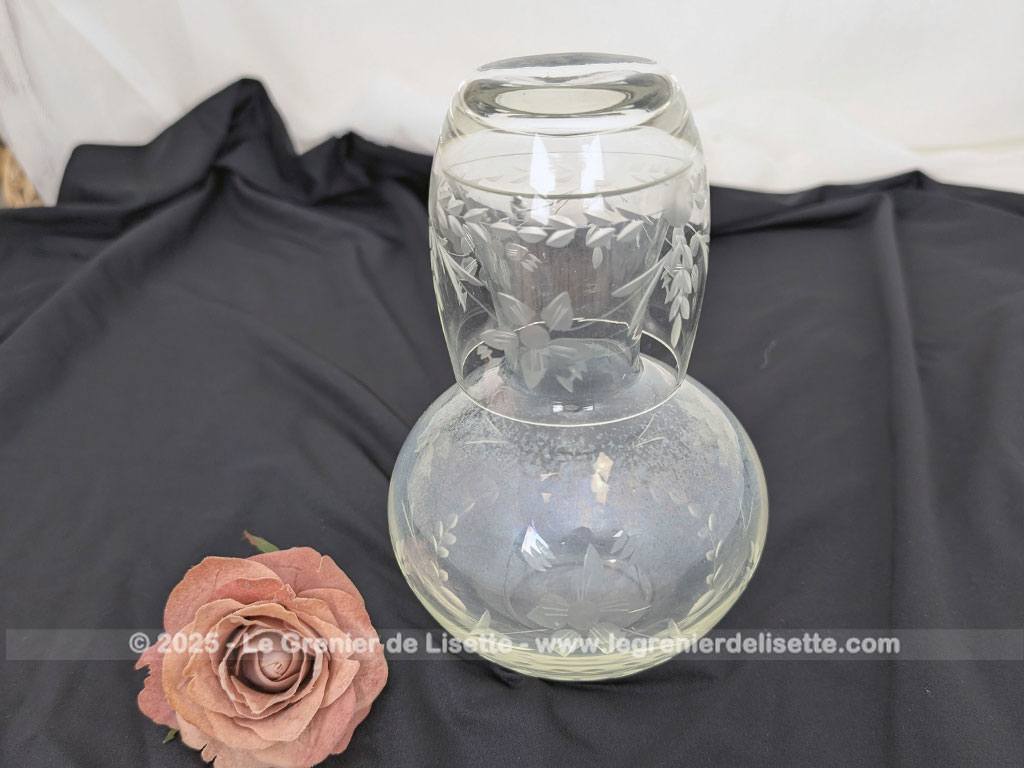 Voici un bel ensemble de nuit vintage comprenant une carafe à eau et son verre assorti faisant office de bouchon, en verre transparent finement ciselé de motifs floraux. Parfait pour une décoration de chambre rétro, romantique ou shabby.