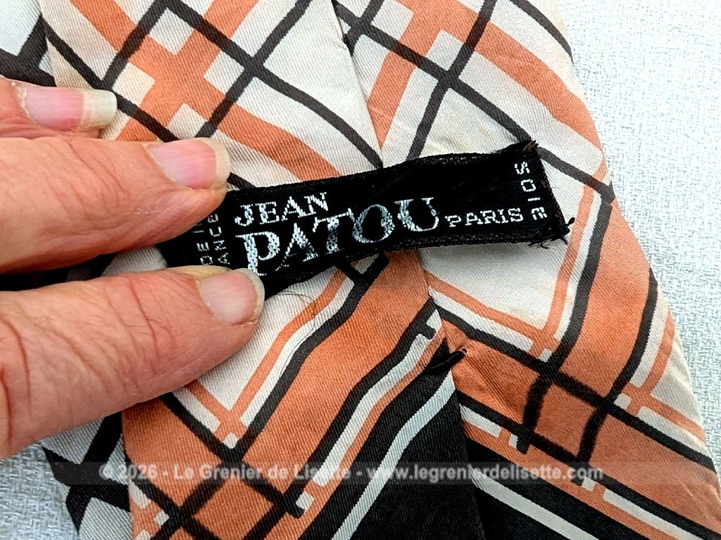 Voici une belle cravate vintage des années 70 de la marque Jean Patou en soie écrue et décorée de formes géométriques couleur chocolat et oranges.Doublure soie également estampillée Jean Patou.