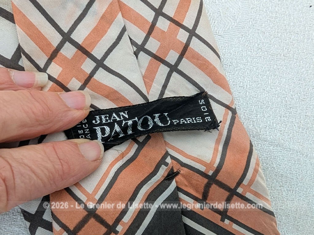 Voici une belle cravate vintage des années 70 de la marque Jean Patou en soie écrue et décorée de formes géométriques couleur chocolat et oranges.Doublure soie également estampillée Jean Patou.