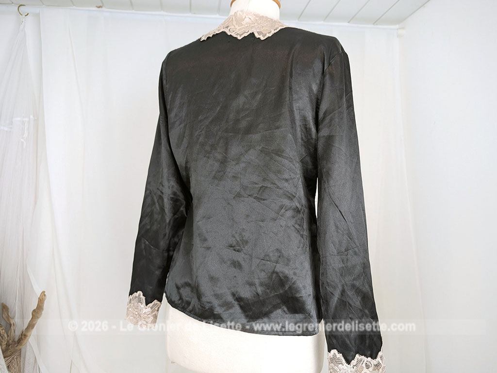 Elégant déshabillé en veste courte d'intérieur polyester, polyamide et élastane noire et décoré de large dentelle écrue.Marque