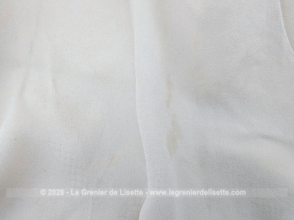 Fait main, voici une écharpe en voile de crêpe gris taupe de 80 x 154 cm, orné d'un grand R brodé et décoré aux extrémités d'un jour de Venise. Pour une écharpe discrète, originale et unique.