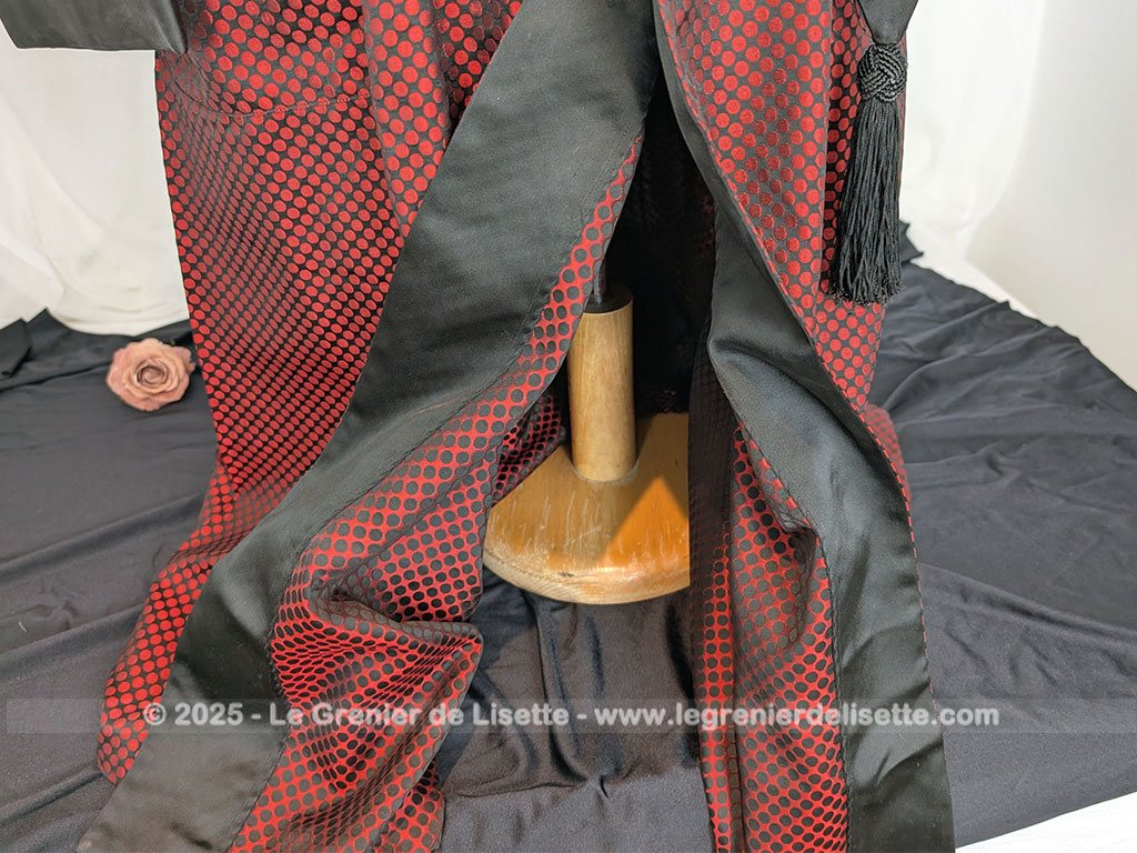 Voici une véritable veste d'intérieur pour homme en tissus satiné jacquard rouge et noir décoré de large bandes de satin noir et portant l'étiquette de la célèbre maison des maitres-tailleur "Lacazes Frères" à Lourdes. Une très belle pièce vintage !