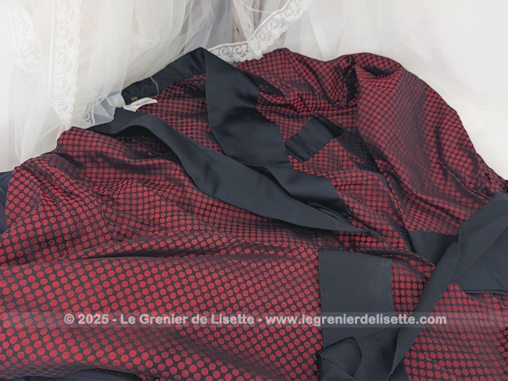 Voici une véritable veste d'intérieur pour homme en tissus satiné jacquard rouge et noir décoré de large bandes de satin noir et portant l'étiquette de la célèbre maison des maitres-tailleur "Lacazes Frères" à Lourdes. Une très belle pièce vintage !