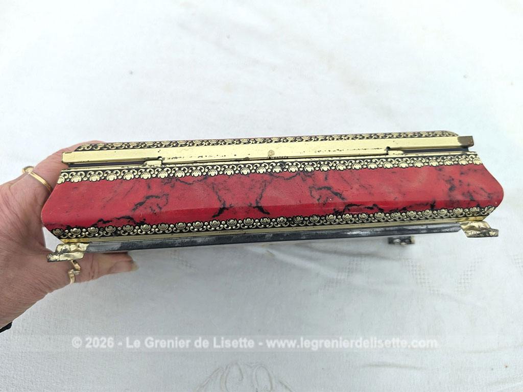 De forme rectangulaire, voici une ancienne belle boite métallique sérigraphiée en rouge, noir et or avec sur le couvercle une fleur dorée en relief et ses 4 pieds ouvragés