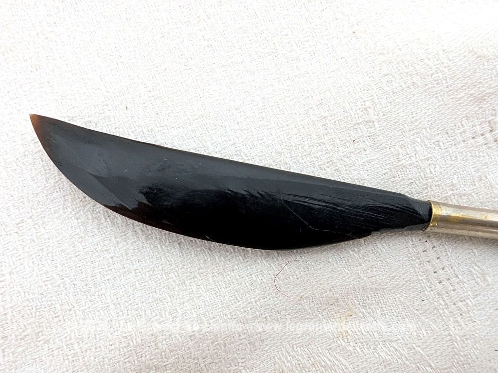 Voici un élégant coupe-papier des années 90, composé d'une lame en plastique épais noir, peut-être en bakélite à la ligne courbe et d'un manche en métal argenté aux motifs ciselés très décoratifs. Pièce artisanale pleine de charme qui remplit parfaitement sa fonction avec originalité.