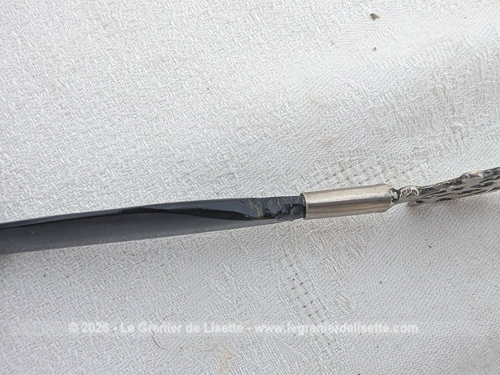 Voici un élégant coupe-papier des années 90, composé d'une lame en plastique épais noir, peut-être en bakélite à la ligne courbe et d'un manche en métal argenté aux motifs ciselés très décoratifs. Pièce artisanale pleine de charme qui remplit parfaitement sa fonction avec originalité.