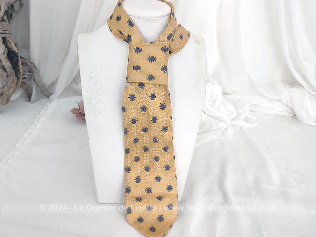 Elégante cravate vintage de la prestigieuse maison Pierre Cardin, 100% soie ocre jaune rehaussée de motifs géométriques tissés bleu et blanc, un style rétro chic très raffiné.