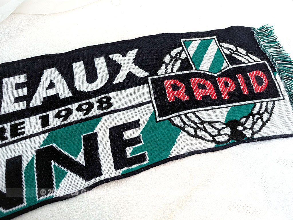 Voici une écharpe collector éditée pour la double confrontation en Coupe de l'UEFA les 15 et 29 septembre 1998 entre les Girondins de Bordeaux et le SK Rapid de Vienne. En très bon état avec ses franges et ses couleurs d'origine.