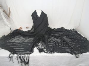 Voici un grand châle carré en voile noir léger, bordé de longues franges sur les quatre côtés. Avec ses rayures satinées sur la bordure et sa belle transparence, il est tout à fait dans le style des années folles. Un accessoire de mode élégant et fluide.