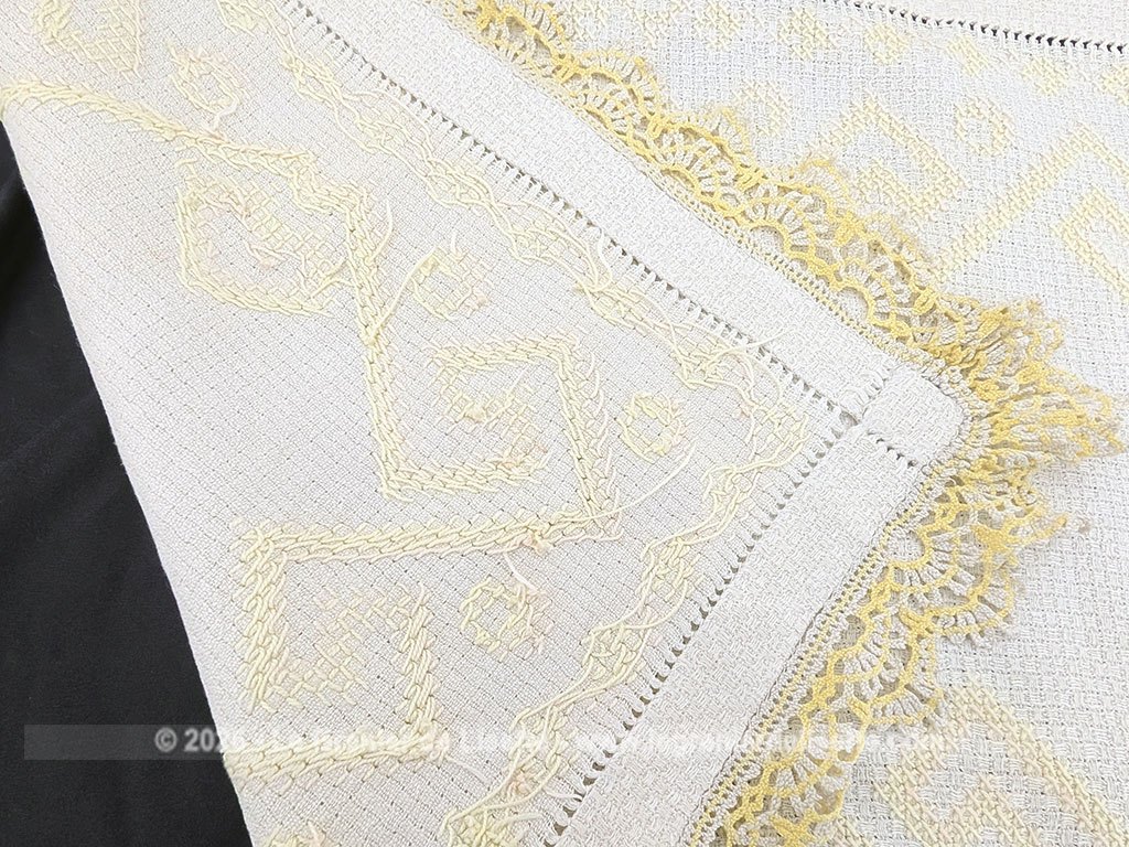Ancien napperon original brodé de motifs géométriques au point de croix en fil jaune et bordé de dentelle aux fuseaux bicolore. Fait main et pièce unique.