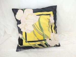 Voici un coussin en soie de 39 cm par 38 cm entièrement peint à la main avec un décor de lys blancs sur un fond noir et jaune et  signé des initiales 