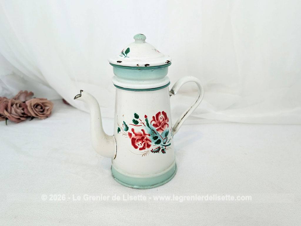 Voici une charmante ancienne cafetière émaillée en blanc et dégradé de vert pale et décorée d'un joli bouquet de roses fuchsia et soulignée de vert, complète avec son filtre et sa passoire. Quelques éclats d'émail dus au temps qui lui donnent tout son charme !