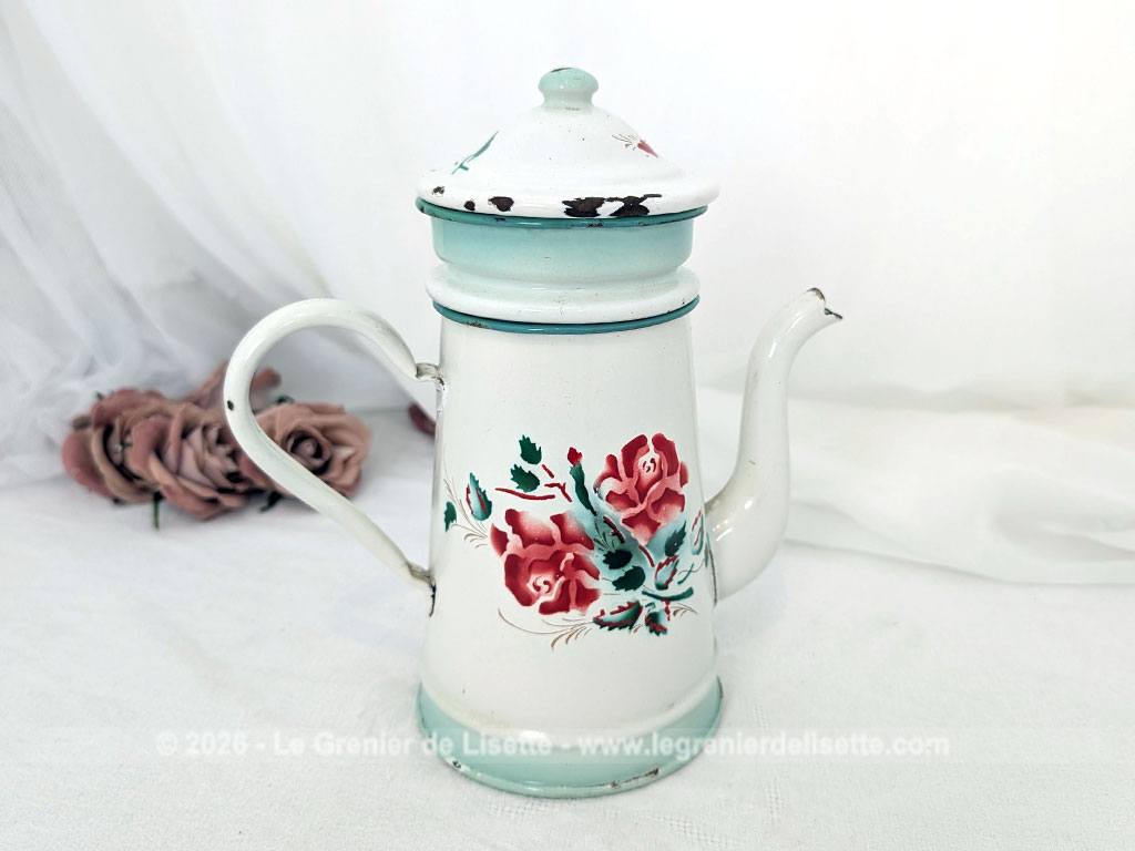 Voici une charmante ancienne cafetière émaillée en blanc et dégradé de vert pale et décorée d'un joli bouquet de roses fuchsia et soulignée de vert, complète avec son filtre et sa passoire. Quelques éclats d'émail dus au temps qui lui donnent tout son charme !