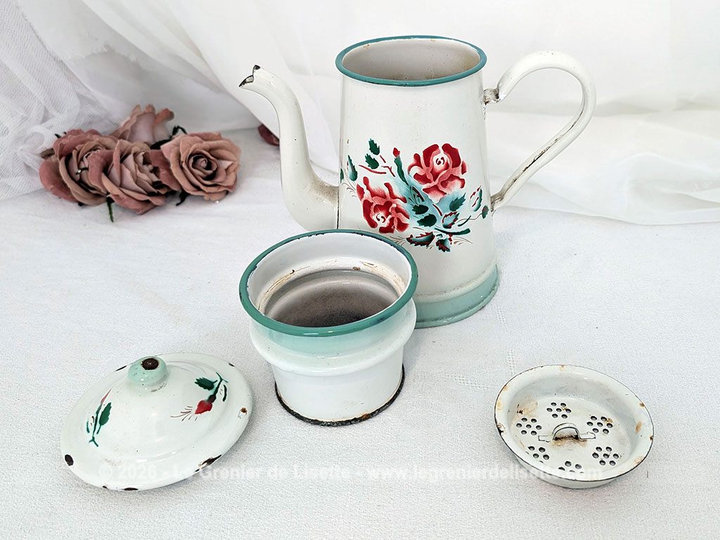 Voici une charmante ancienne cafetière émaillée en blanc et dégradé de vert pale et décorée d'un joli bouquet de roses fuchsia et soulignée de vert, complète avec son filtre et sa passoire. Quelques éclats d'émail dus au temps qui lui donnent tout son charme !