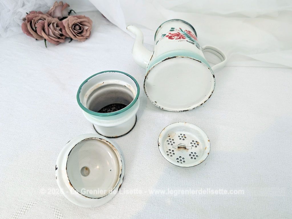 Voici une charmante ancienne cafetière émaillée en blanc et dégradé de vert pale et décorée d'un joli bouquet de roses fuchsia et soulignée de vert, complète avec son filtre et sa passoire. Quelques éclats d'émail dus au temps qui lui donnent tout son charme !