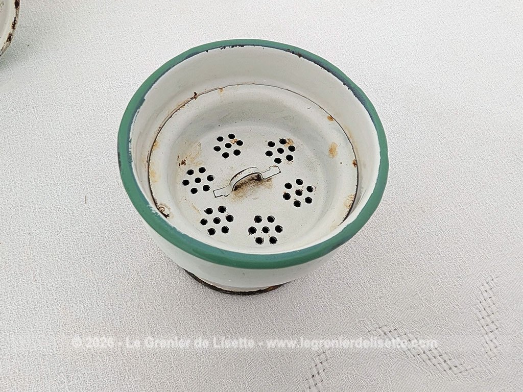 Voici une charmante ancienne cafetière émaillée en blanc et dégradé de vert pale et décorée d'un joli bouquet de roses fuchsia et soulignée de vert, complète avec son filtre et sa passoire. Quelques éclats d'émail dus au temps qui lui donnent tout son charme !