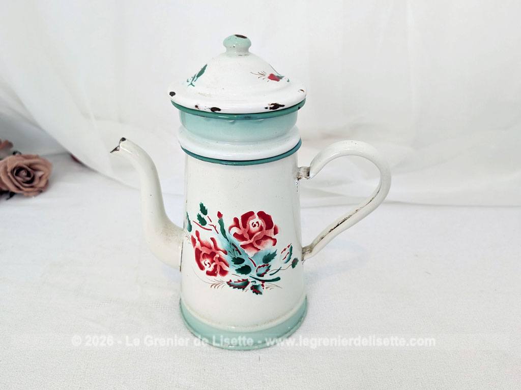 Voici une charmante ancienne cafetière émaillée en blanc et dégradé de vert pale et décorée d'un joli bouquet de roses fuchsia et soulignée de vert, complète avec son filtre et sa passoire. Quelques éclats d'émail dus au temps qui lui donnent tout son charme !