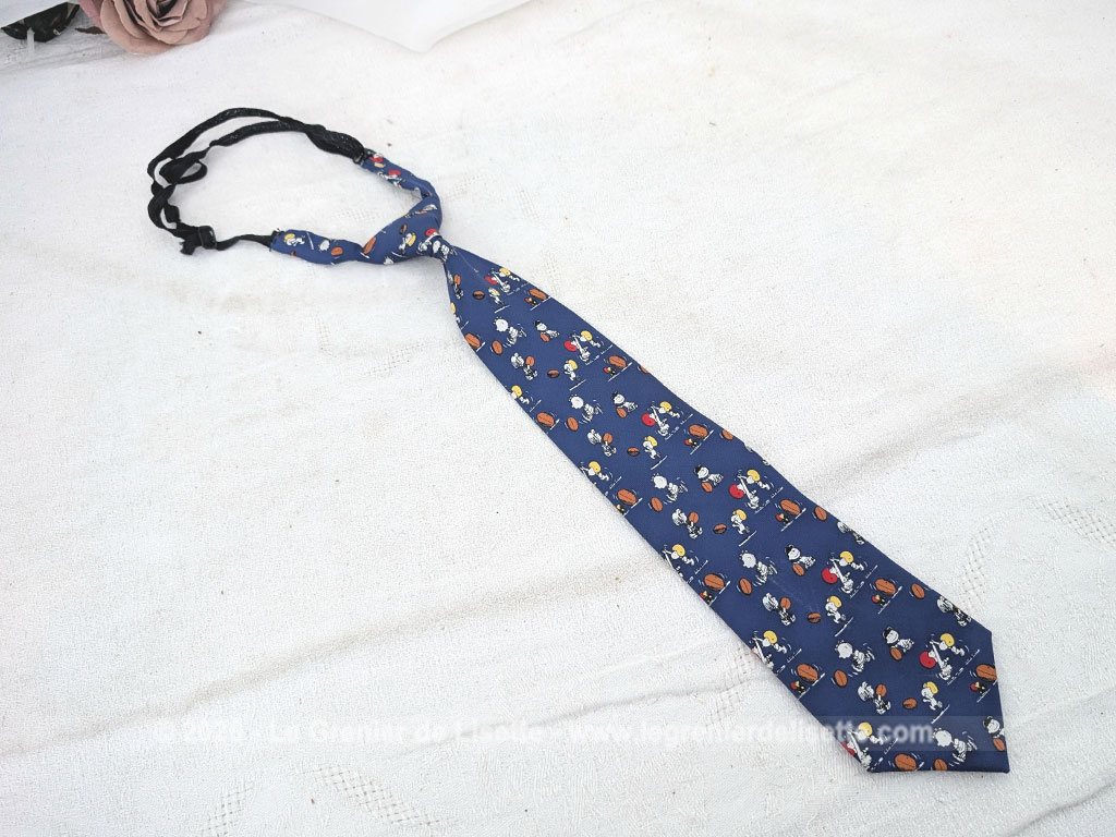 Pour garçonnet, voici une petite cravate vintage en 100% soie pour les fans de la bande à Snoopy, avec les personnages cultes comme Charlie Brown ou Lucy en pleine action sur un terrain de rugby. Facile à ajuster avec son système d'attache à élastique réglable.