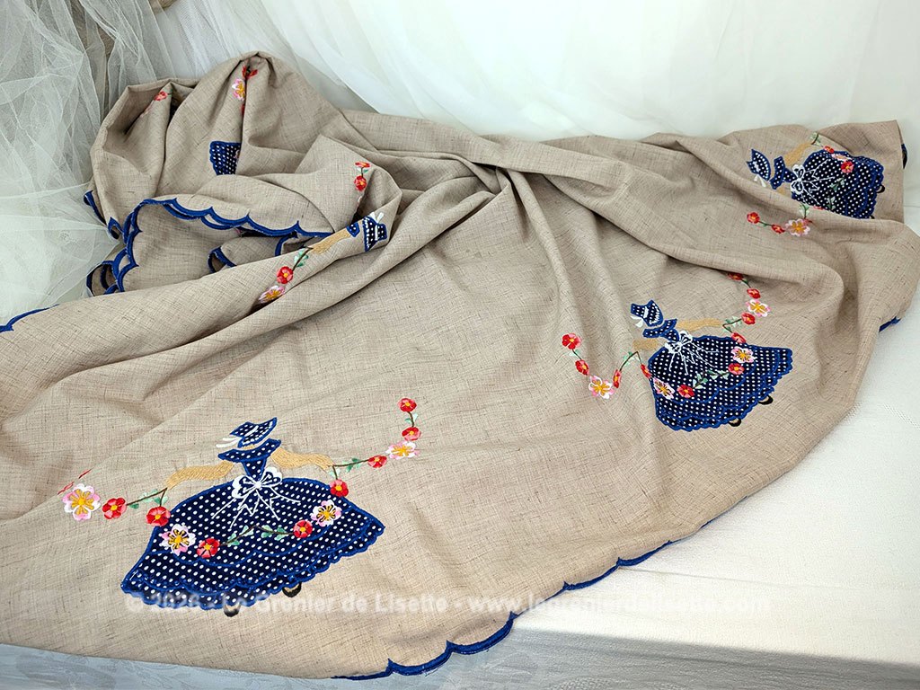 Sur 150 x 210 cm, voici une magnifique et grande nappe au look rétro et champêtre richement ornée de personnages aux robes en incrustations de tissu bleu à pois finement brodées. Idéale pour apporter une touche romantique et authentique à vos repas de famille.