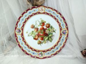 Superbe assiette de collection d'une finesse rare, datant du XIXe siècle avec en décor central des fraises des bois entièrement peint à la main et décoré d'un monogramme doré ainsi que des motifs fleuris. Pièce d'exception signée au dos 