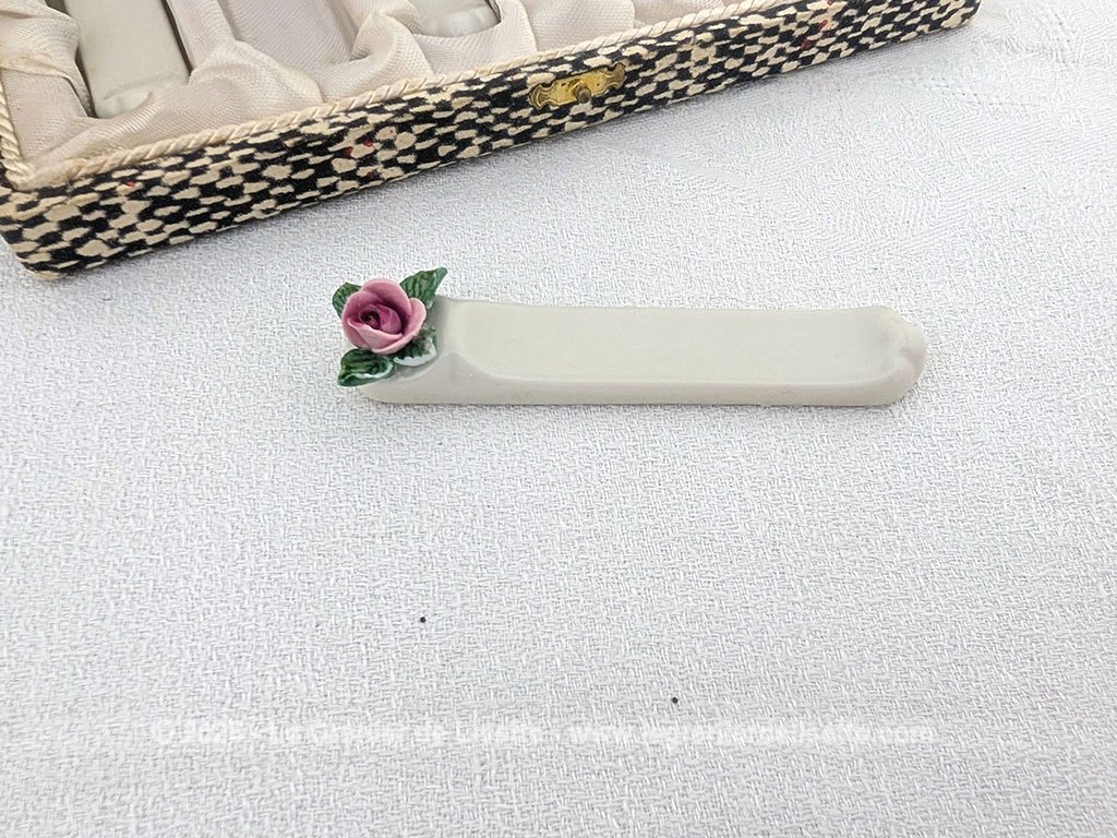 Voici un superbe coffret ancien comprenant 6 porte-couteaux en porcelaine blanche de Limoges, estampillés et numéroté et ornés d'une délicate rose en relief aux tons rose et vert. Présentés dans leur coffret d'origine tapissé de satin ivoire pour apporter une note romantique à vos tables de réception.