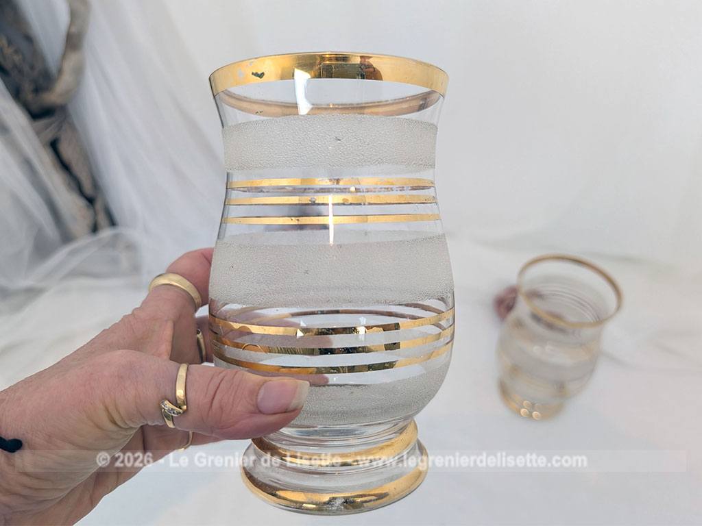 Sur 16 cm de haut et 9 cm de large, voici un duo de petits vases vintage qui jouent sur le contraste de matières avec une alternance de bandes de verre granité à l'aspect givré et de larges anneaux dorés.
