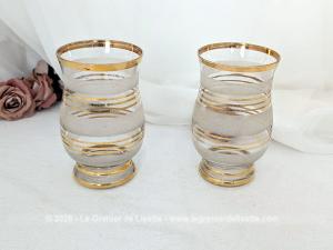 Sur 16 cm de haut et 9 cm de large, voici un duo de petits vases vintage qui jouent sur le contraste de matières avec une alternance de bandes de verre granité à l'aspect givré et de larges anneaux dorés.