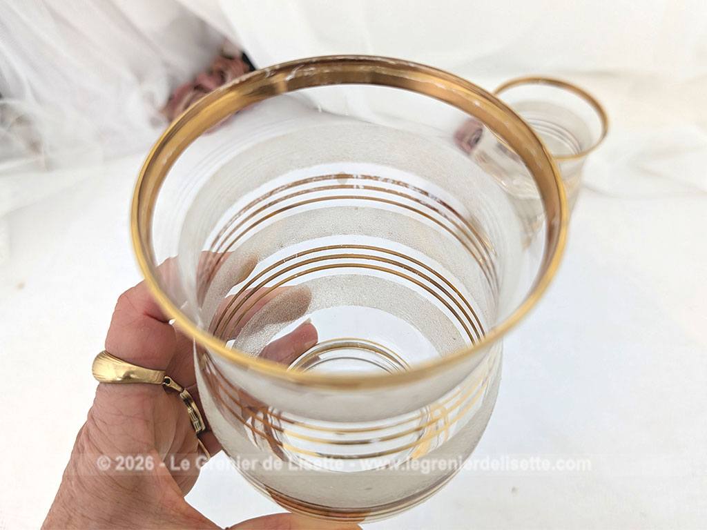 Sur 16 cm de haut et 9 cm de large, voici un duo de petits vases vintage qui jouent sur le contraste de matières avec une alternance de bandes de verre granité à l'aspect givré et de larges anneaux dorés.