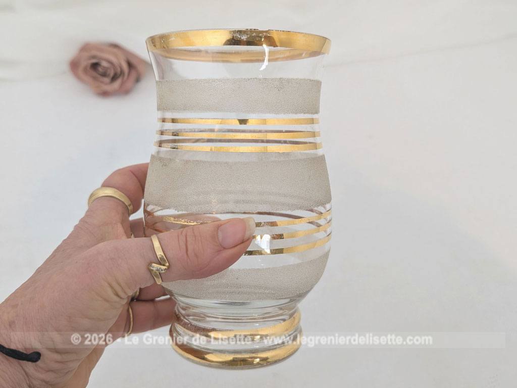 Sur 16 cm de haut et 9 cm de large, voici un duo de petits vases vintage qui jouent sur le contraste de matières avec une alternance de bandes de verre granité à l'aspect givré et de larges anneaux dorés.