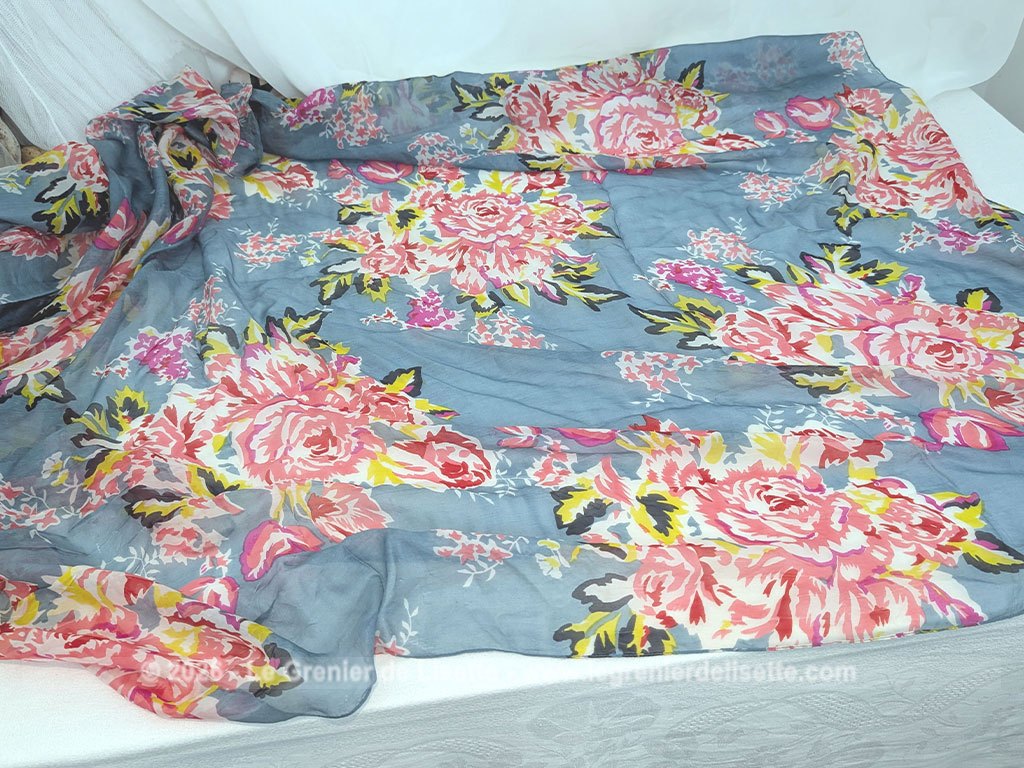 Sur 175 x 150 cm, voici un superbe foulard vintage en coton mélangé viscose, tout doux au toucher et decoré de gros bouquets de fleurs rosés sur un fond bleu gris. Etiquette