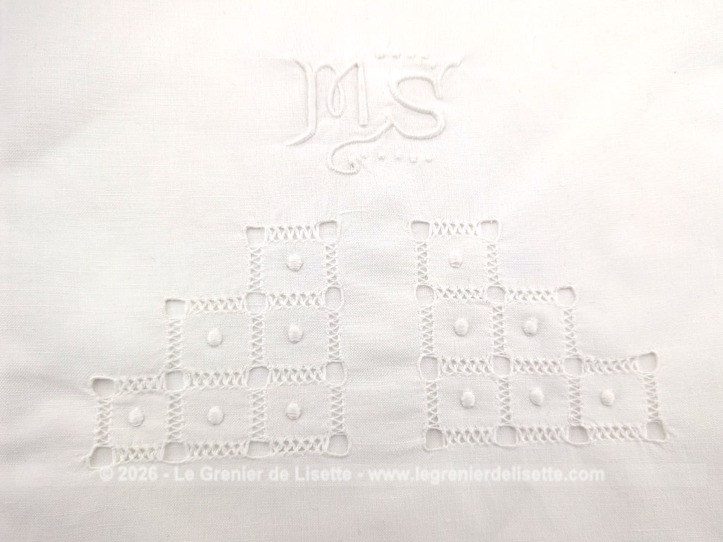 Voici un magnifique drap ancien de 90 x 126 cm pour berceau ou lit de bébé en coton blanc orné d'un superbe travail de jours de broderies géométriques et d'un élégant monogramme MS brodé à la main.
