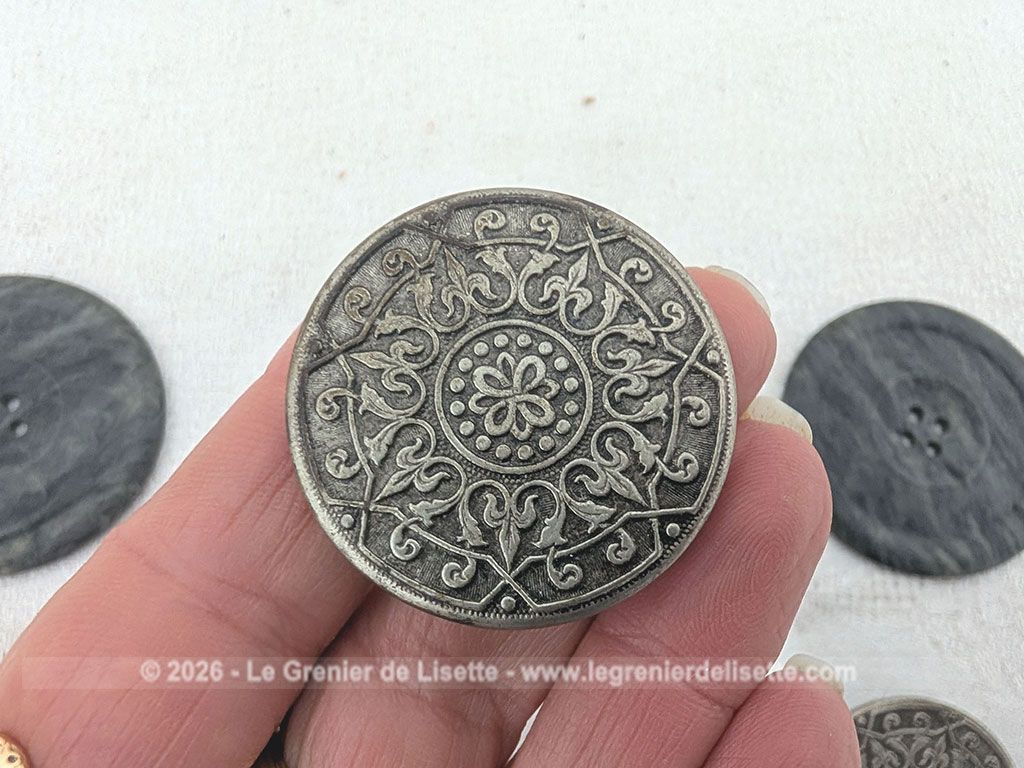 Voici un très beau lot de boutons anciens de mercerie comprenant quatre grands boutons sombres, deux modèles ciselés et une magnifique pièce travaillée en argent véritable porteuse d'un poinçon officiel au dos.