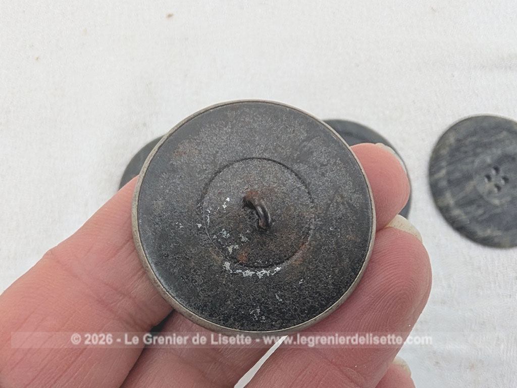 Voici un très beau lot de boutons anciens de mercerie comprenant quatre grands boutons sombres, deux modèles ciselés et une magnifique pièce travaillée en argent véritable porteuse d'un poinçon officiel au dos.