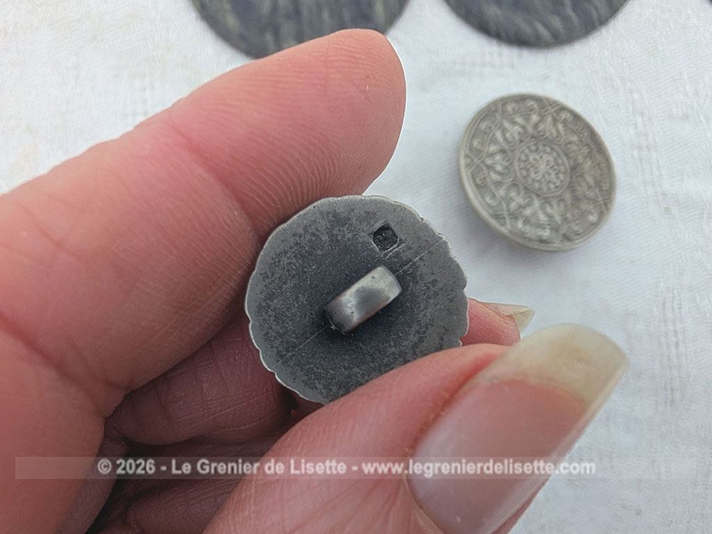 Voici un très beau lot de boutons anciens de mercerie comprenant quatre grands boutons sombres, deux modèles ciselés et une magnifique pièce travaillée en argent véritable porteuse d'un poinçon officiel au dos.