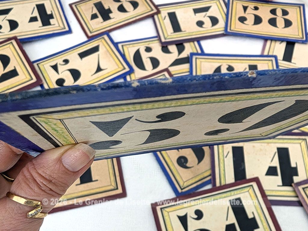 Voici un lot 23 plaques anciennes de 11.5 x 15.5 cm en carton épais imprimées de numéros noirs probablement issues d'anciens systèmes de gestion pour les vestiaires de théâtres ou tirage de loteries de kermesses. Idée de décoration originale !