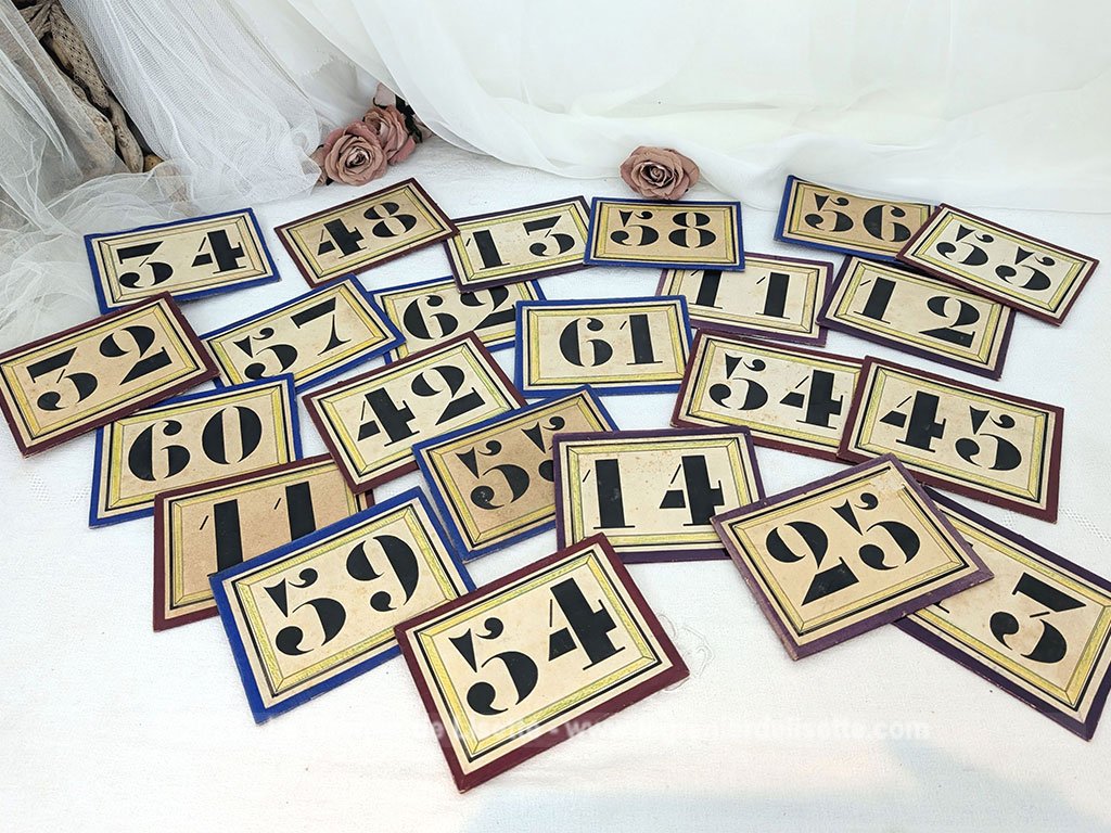 Voici un lot 23 plaques anciennes de 11.5 x 15.5 cm en carton épais imprimées de numéros noirs probablement issues d'anciens systèmes de gestion pour les vestiaires de théâtres ou tirage de loteries de kermesses. Idée de décoration originale !