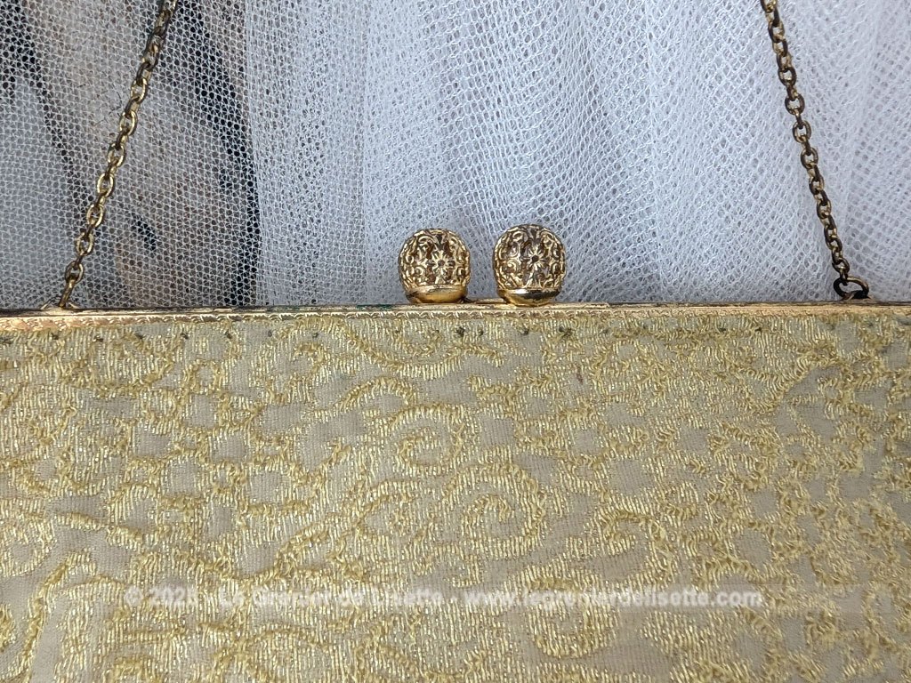 Voici une belle minaudière habillée de tissus léger et gaufré avec des reliefs dorés et une doublure en nylon cousu à la main, sans étiquette de marque mais un superbe fermoir ciselé et ouvragé et une fine chaine dorée. Fermoir années 70/80.
