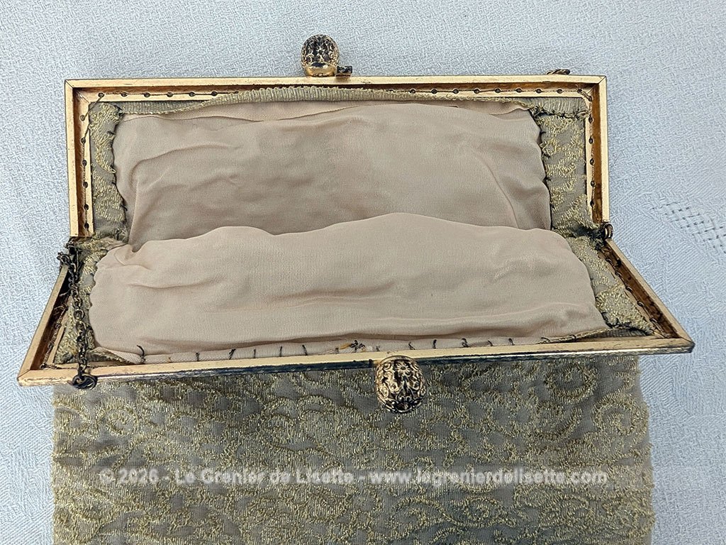 Voici une belle minaudière habillée de tissus léger et gaufré avec des reliefs dorés et une doublure en nylon cousu à la main, sans étiquette de marque mais un superbe fermoir ciselé et ouvragé et une fine chaine dorée. Fermoir années 70/80.
