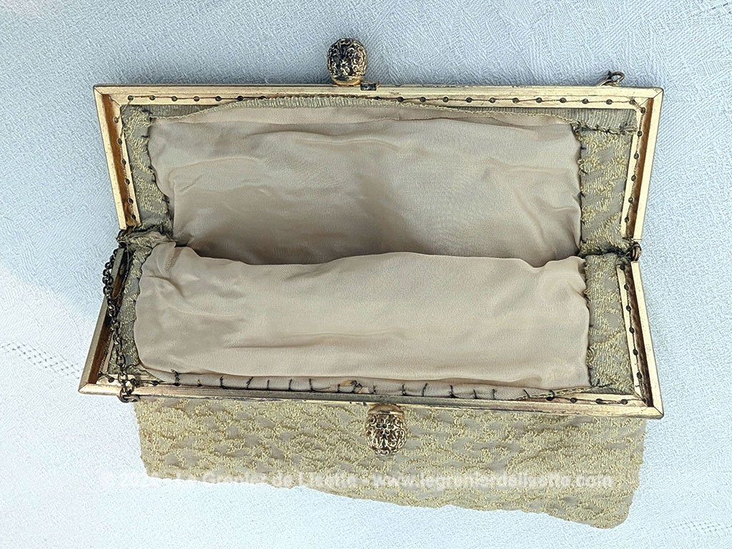 Voici une belle minaudière habillée de tissus léger et gaufré avec des reliefs dorés et une doublure en nylon cousu à la main, sans étiquette de marque mais un superbe fermoir ciselé et ouvragé et une fine chaine dorée. Fermoir années 70/80.